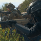 Soldiers advance forward with weapons drawn.